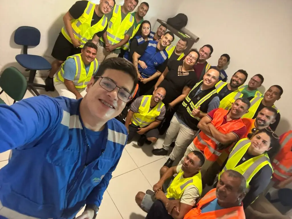 Colaboradores da IRLog reunidos em sala de treinamento, com coletes de segurança e uniformes, demonstrando engajamento, capacitação e espírito de equipe na logística