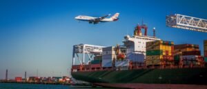 Navio cargueiro com contêineres no porto e avião sobrevoando, representando a atuação multimodal da IRLog no transporte marítimo e aéreo