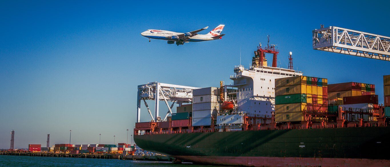 Navio cargueiro com contêineres no porto e avião sobrevoando, representando a atuação multimodal da IRLog no transporte marítimo e aéreo